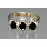 Ring, WG 750, 3 oval facettierte Saphire zus. ca. 1.0 ct., 8 kleine Besatzbrillanten zus. ca. 0.16