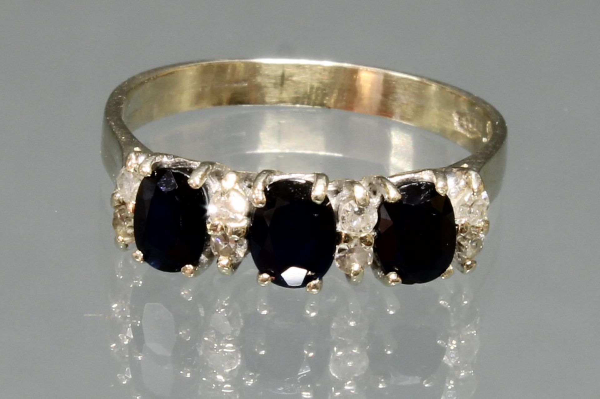 Ring, WG 750, 3 oval facettierte Saphire zus. ca. 1.0 ct., 8 kleine Besatzbrillanten zus. ca. 0.16