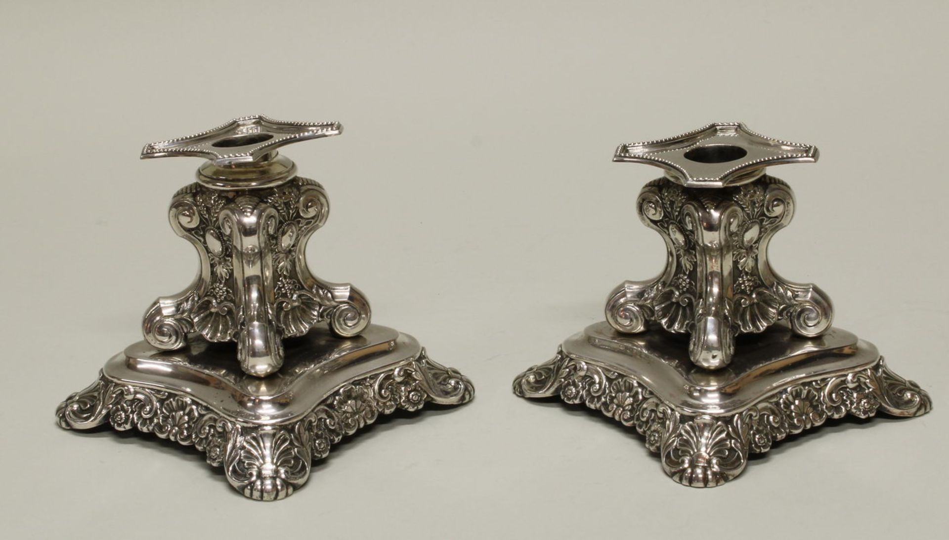 Paar Kerzenleuchter, Silber 13-lötig, 19. Jh., kurzer, vierseitiger Schaft auf Sockelplinthe, Reli