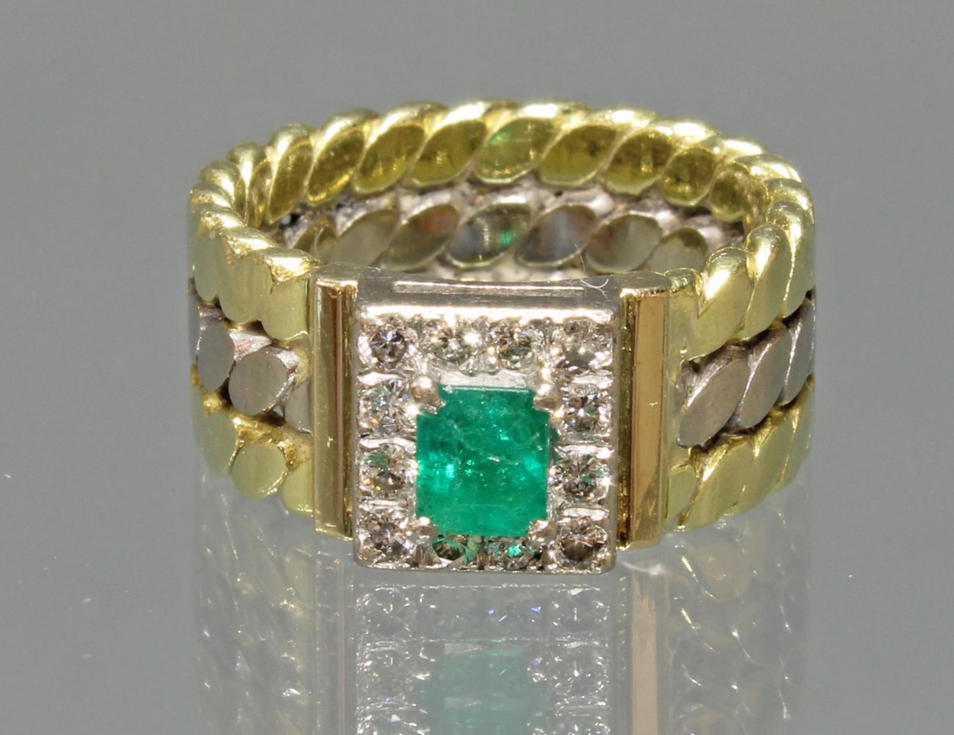 Ring, WG/GG 750, 1 rechteckig facettierter Smaragd (Haarriss) ca. 0.52 ct., 12 Brillanten zus. ca.