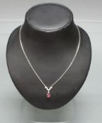 Collier, WG 585, oval facettierter Rubin, 8 Brillanten zus. ca. 0.24 ct., 43 cm lang, 9 g