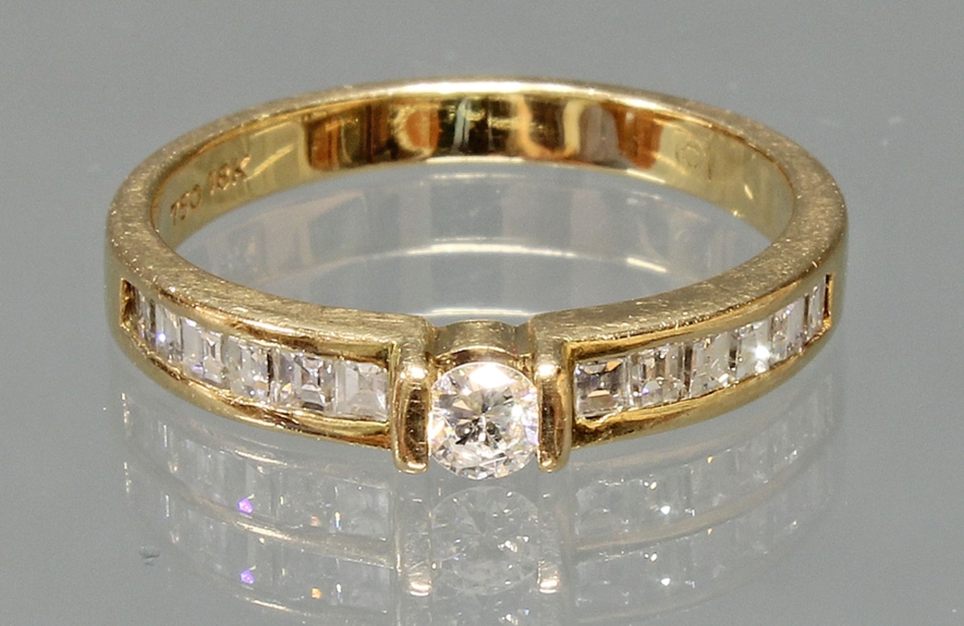 Ring, GG 750, 1 Brillant ca. 0.10 ct., 12 Diamanten im Square-Schliff, 3 g, RM 16.5