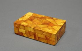 Deckeldose, 19./20. Jh., Bernstein über Holz, 4 x 13.3 x 8.8 cm, kleine Bestoßungen.