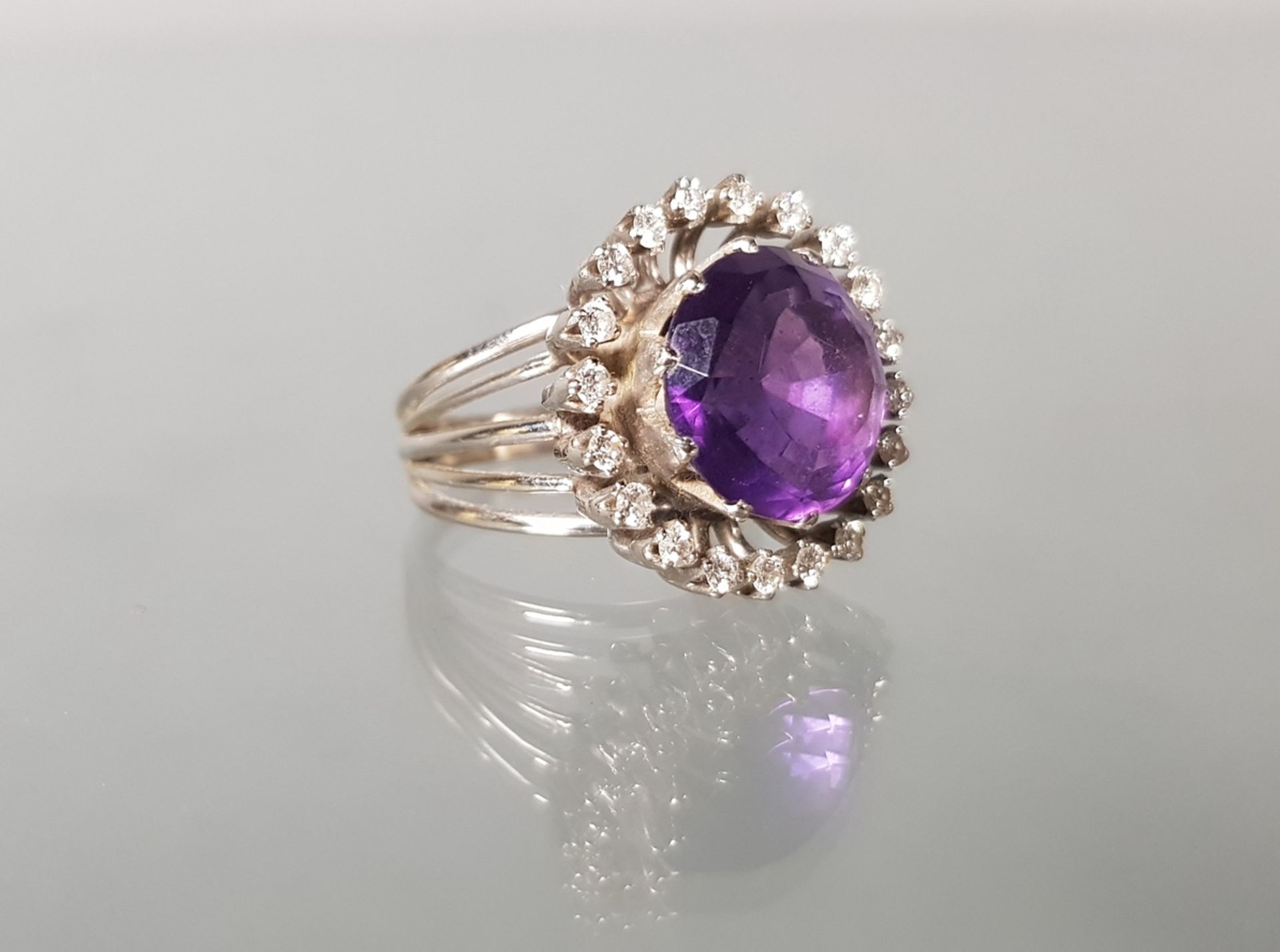 Ring, WG 585, 1 runder facettierter Amethyst ø ca. 9 mm, 20 Diamanten zus. ca. 1.0 ct., 11 g, RM 17