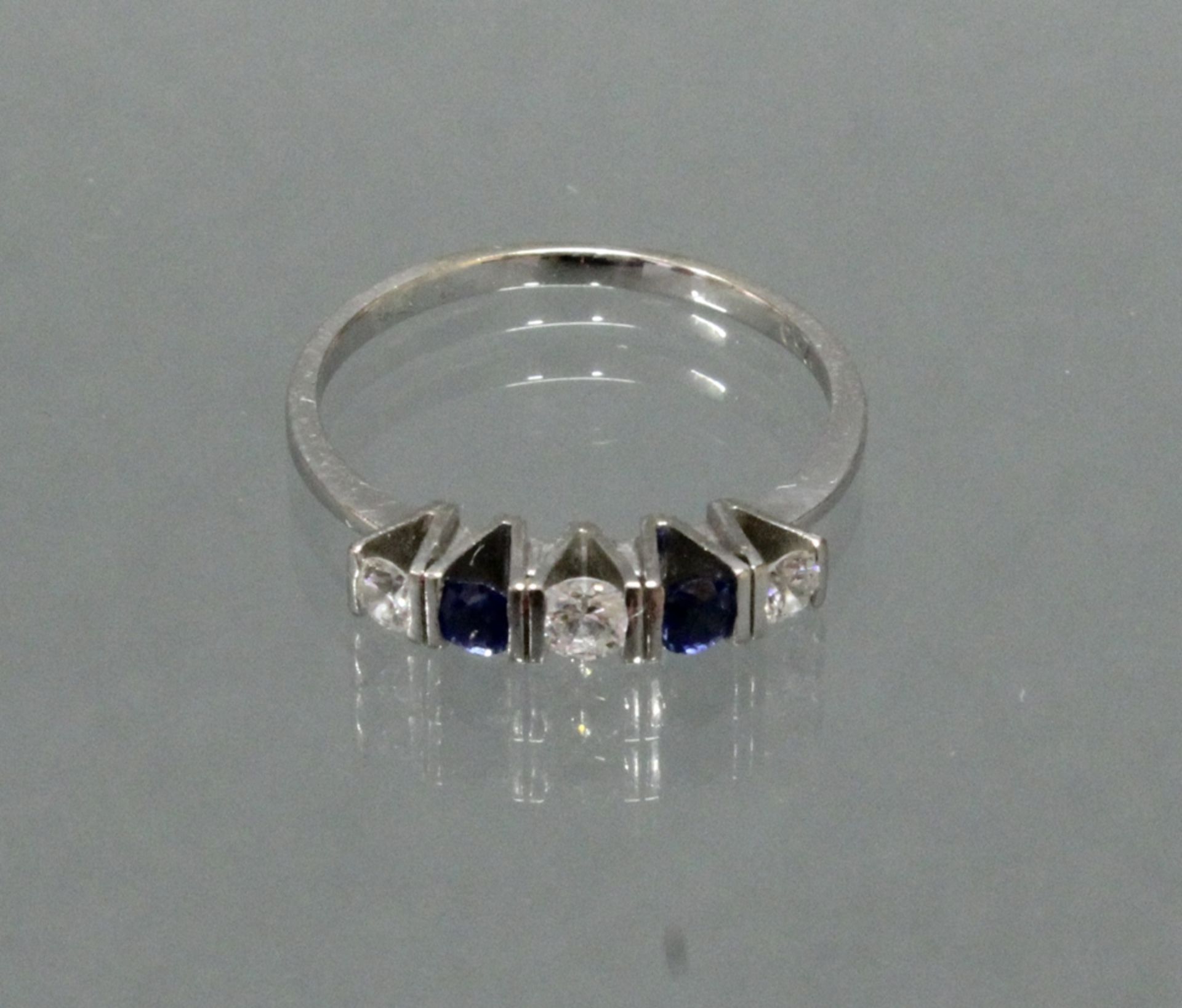 Ring, WG 750, 3 Brillanten zus. ca. 0.20 ct., etwa w/si, 2 runde facettierte Saphire, 2 g, RM 18.5