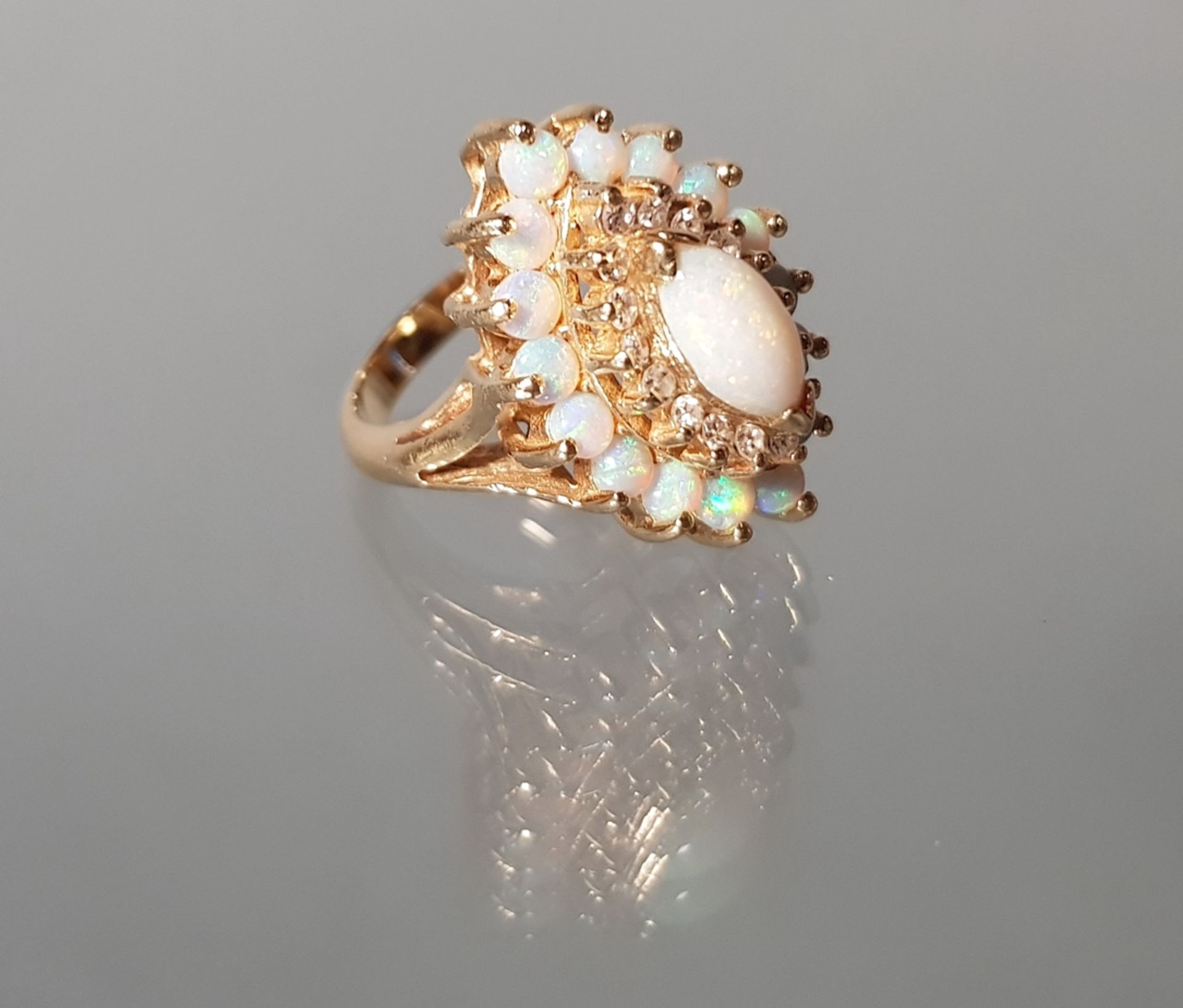 Ring, GG 585, 1 ovaler Opal-Cabochon, 16 runde Opal-Cabochons, 16 Besatz-Diamanten, 9 g, RM 17