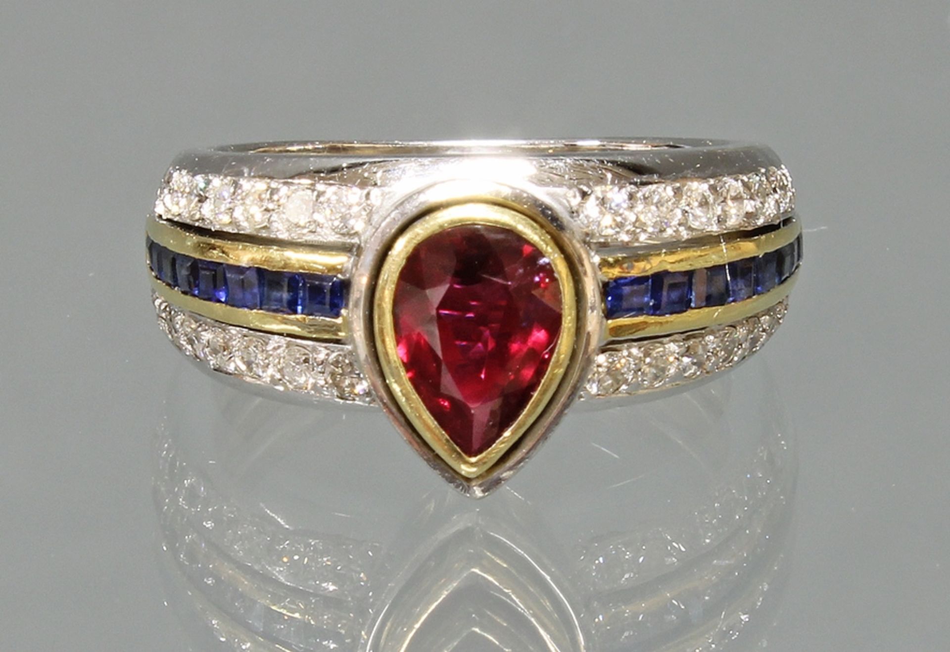 Ring, WG/GG 750, 1 Rubin im Tropfenschliff, 16 Saphircarrées, 28 Diamanten zus. ca. 0.56 ct., 8 g,