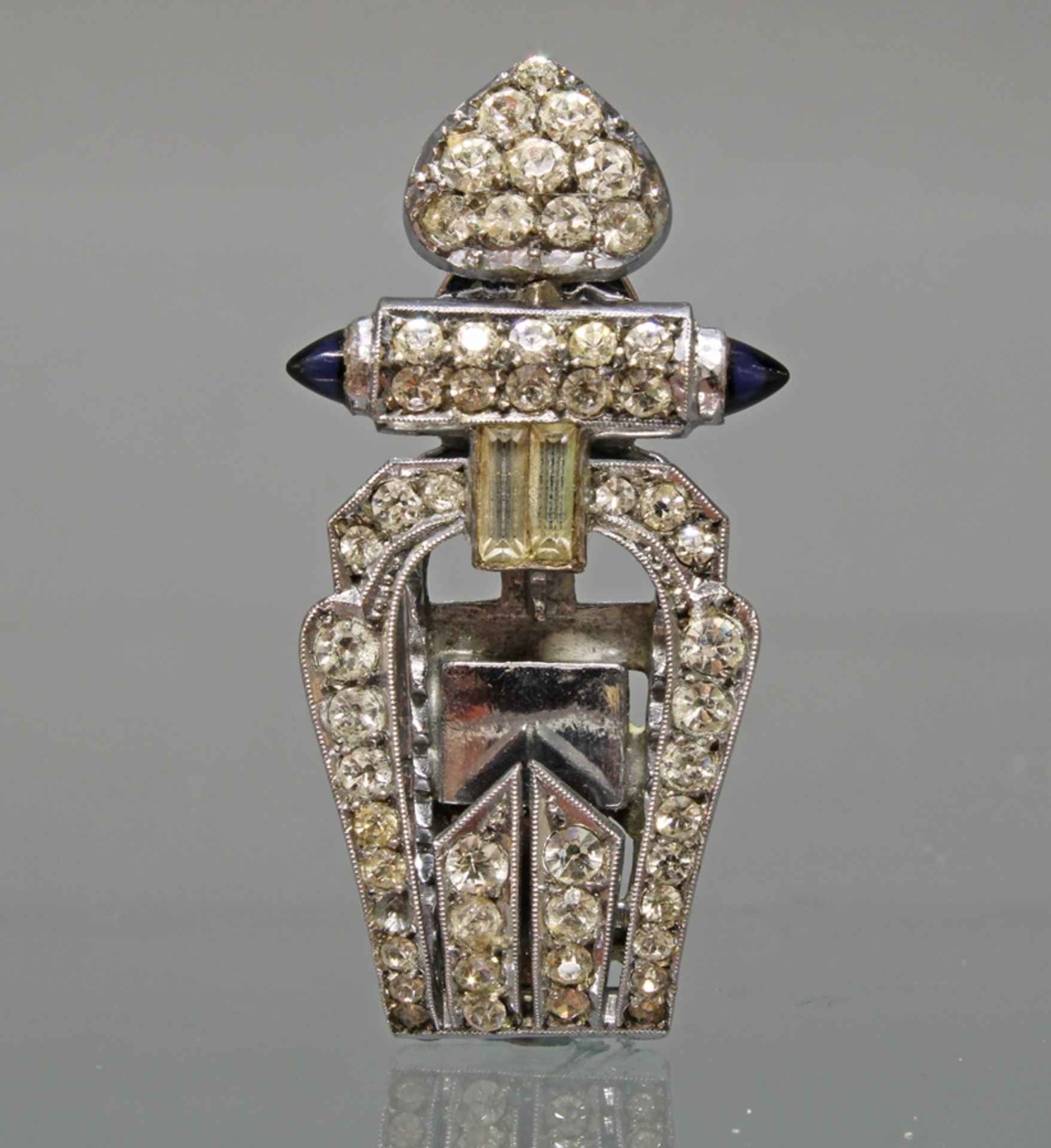 Art Deco-Clip, um 1920/30, Silber 935, weiße Pastesteine, 2 blaue Farbsteine, 4.3 cm.