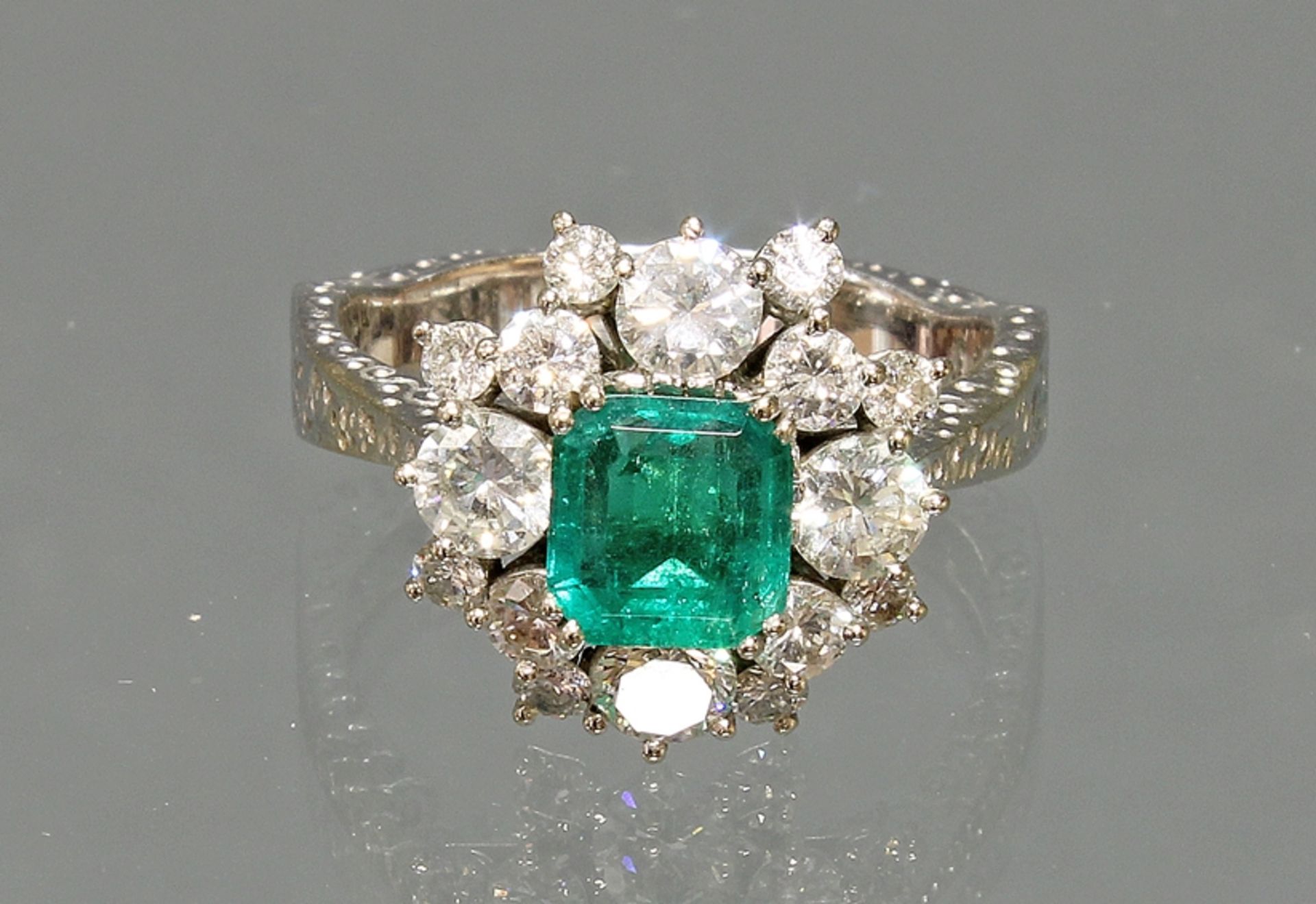 Ring, WG 750, Schiene fein graviert, 1 Smaragd ca. 1.30 ct., Smaragdschliff (Rundiste mit minimalem