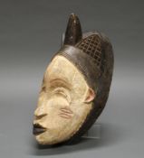 Maske, Punu, Gabun, Afrika, Holz, braun/weiße Bemalung, an den Wangen Tataos, 38 cm hoch.