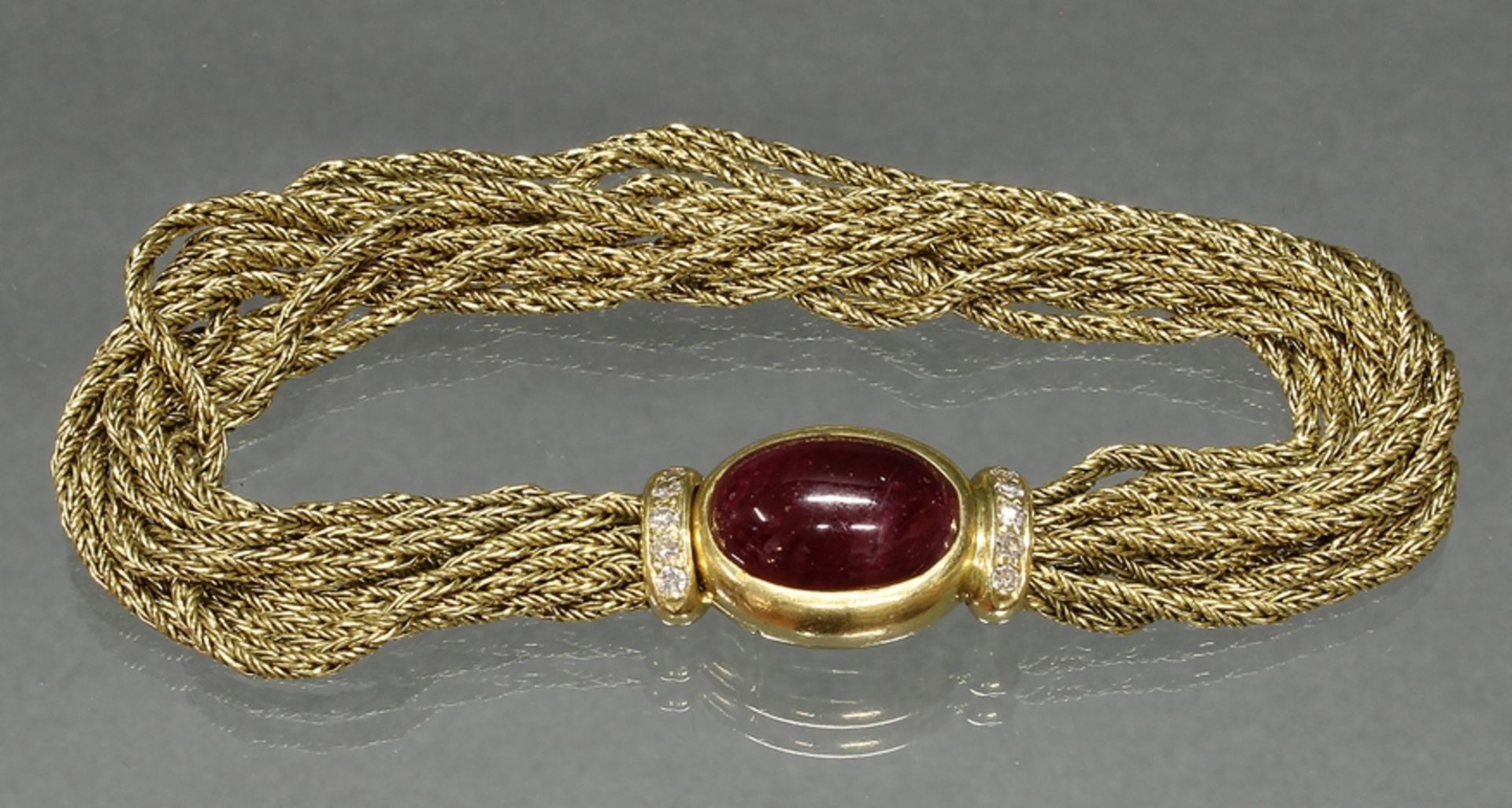 Armband, GG 750, 10 Goldstränge, Schließe ovaler Rubin-Cabochon 14.5 x 10 mm, 10 kleine Besatzdiama