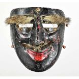 Maske., Schwarzgefärbte Ritualmaske aus Holz mit aufgeklebten Tierfellteilen für Schnauze und Augen