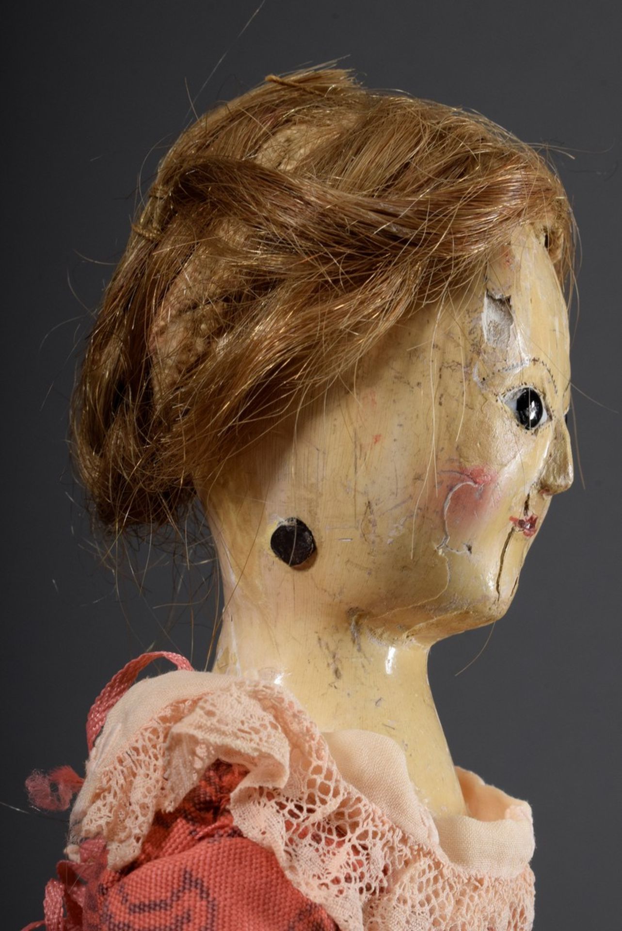 Antike Puppe mit Holzgliederkörper und farbig gefasstem Kopf sowie Glasaugen un - Bild 3 aus 4