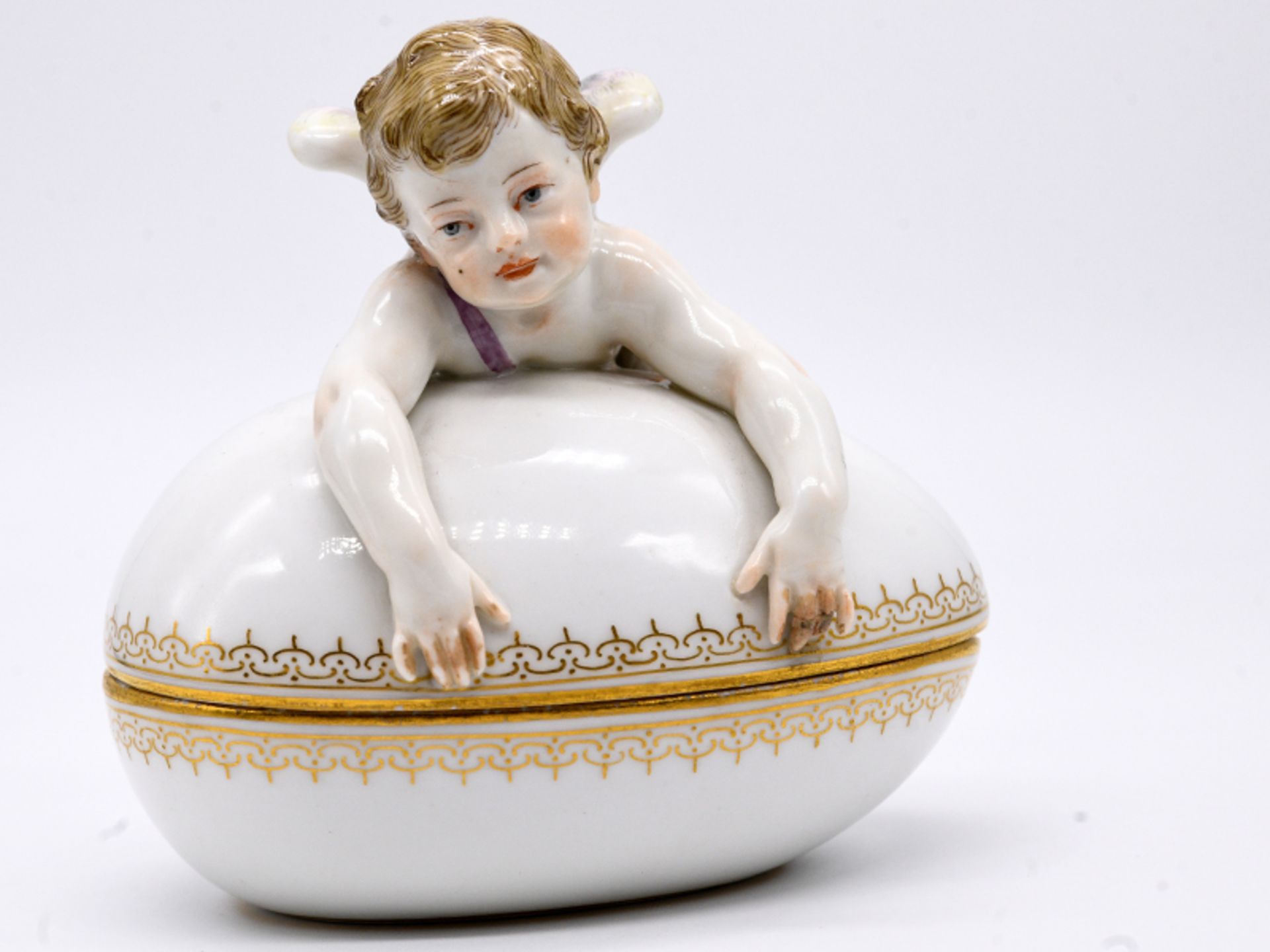 Figürliche Jugendstil-Deckeldose mit Amor; Meissen; um 1900.Weißporzellan mit Farb- und