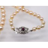 Akoja-Perlenkette mit weißgoldener Schließe und kleinem Rubin; 90- er Jahre.Akoja-Perlen; im