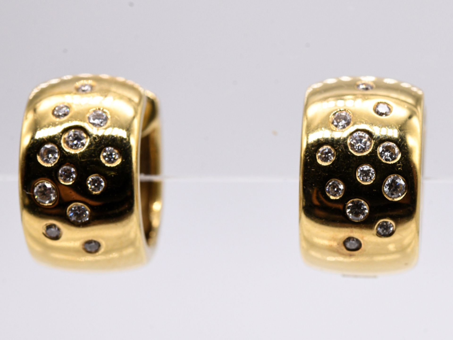 Paar Creolen mit zusammen 24 Brillanten, zus. 0,32 ct, bezeichnet Quinn, 20. Jh. br750/- Gelbgold.