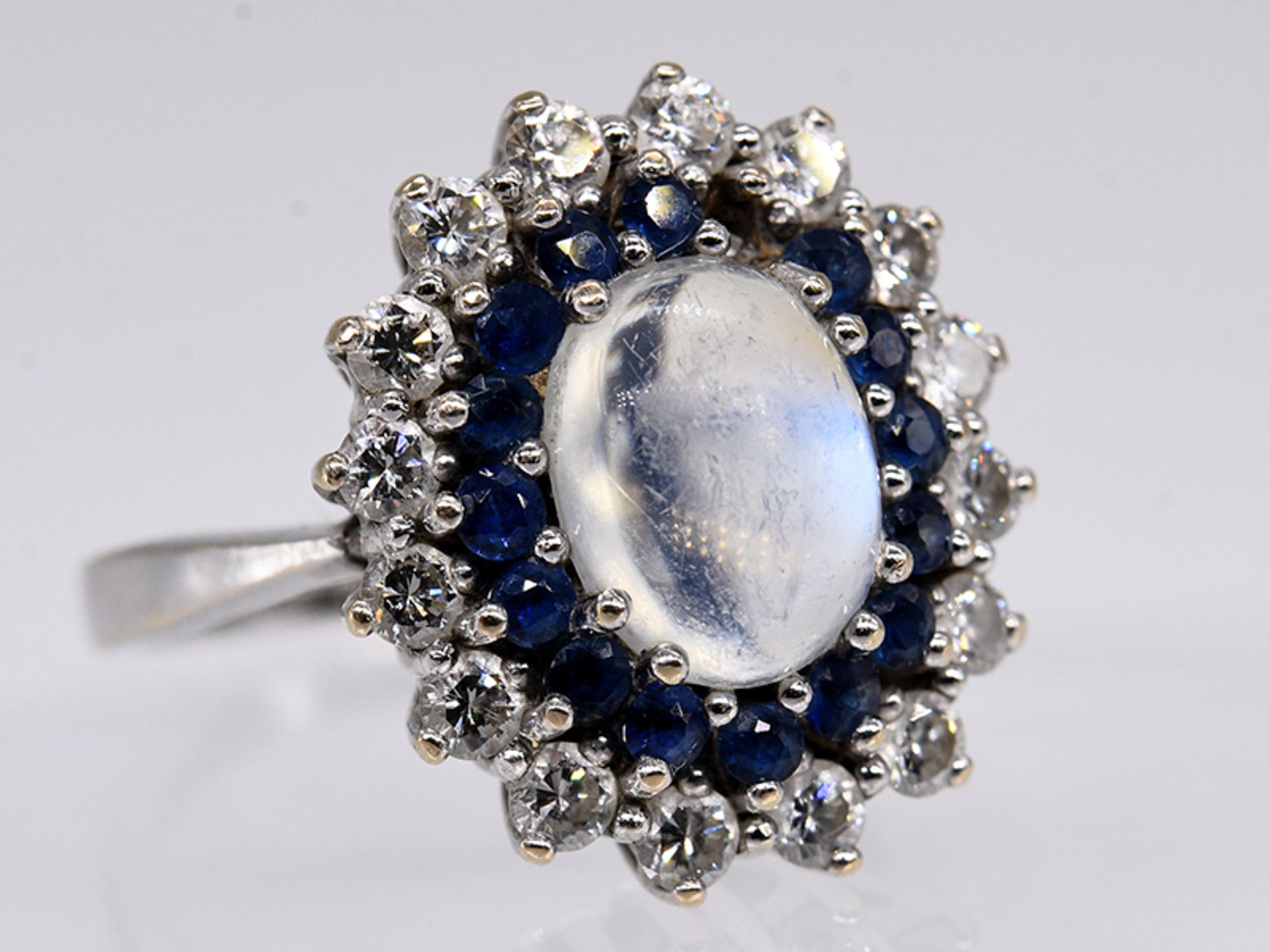 Ring mit Mondsteincabochon ca. 1,2 ct, 16 Saphiren zus. ca. 0,40 ct und 16 Brillanten, zus. ca. 1