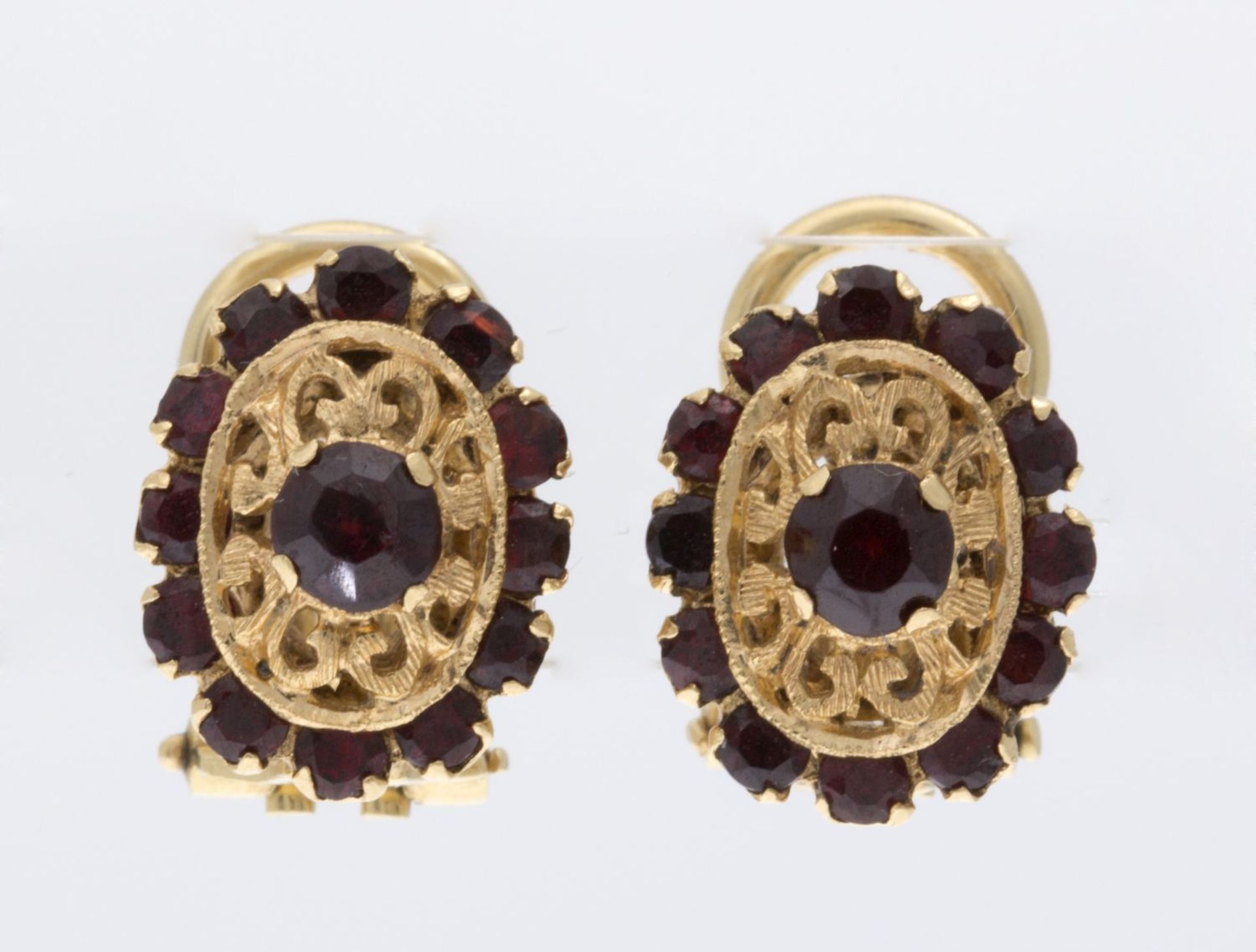 Ein Paar Granat-OhrclipsGelbgold 750. Ovale durchbrochene Form ausgefasst mit kleinen Granate
