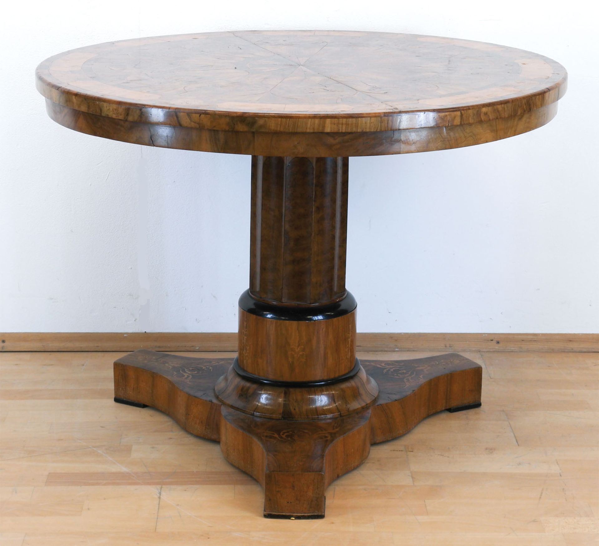 Biedermeier-Tisch, Nußbaum/Maserholz furniert, intarsiert, über 3-passigem Fuß Mittelsäule mit rund