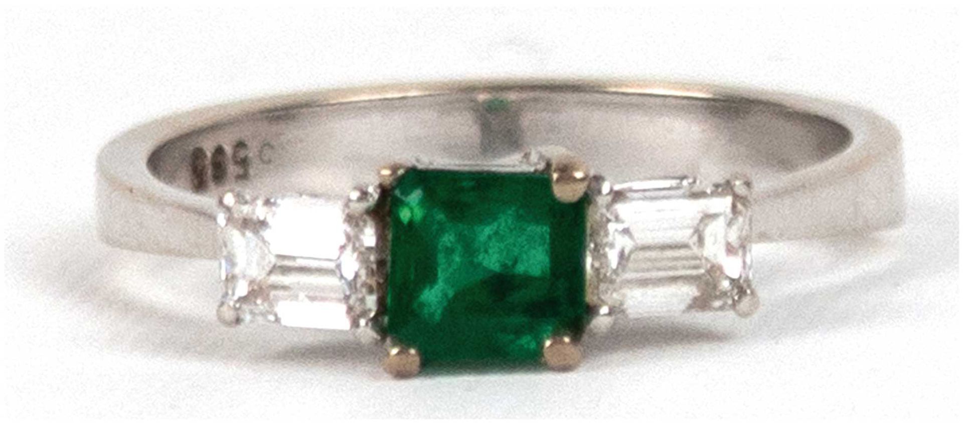 Ring, 585er WG, besetzt mit 2 Diamanten, Emerald-Cut, TW-lr, zus. 0,58 ct. und 1 Smaragd (Kolumbien