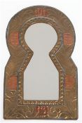 Spiegel in Form eines Schlüsselloches, reliefierter Messingrahmen mit Kupferappliken, ges. 24,5x14,