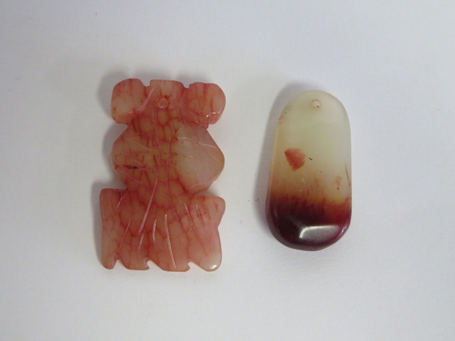 2 Anhänger, China, Jade beschnitzt, l 3,8/4,5 cm.