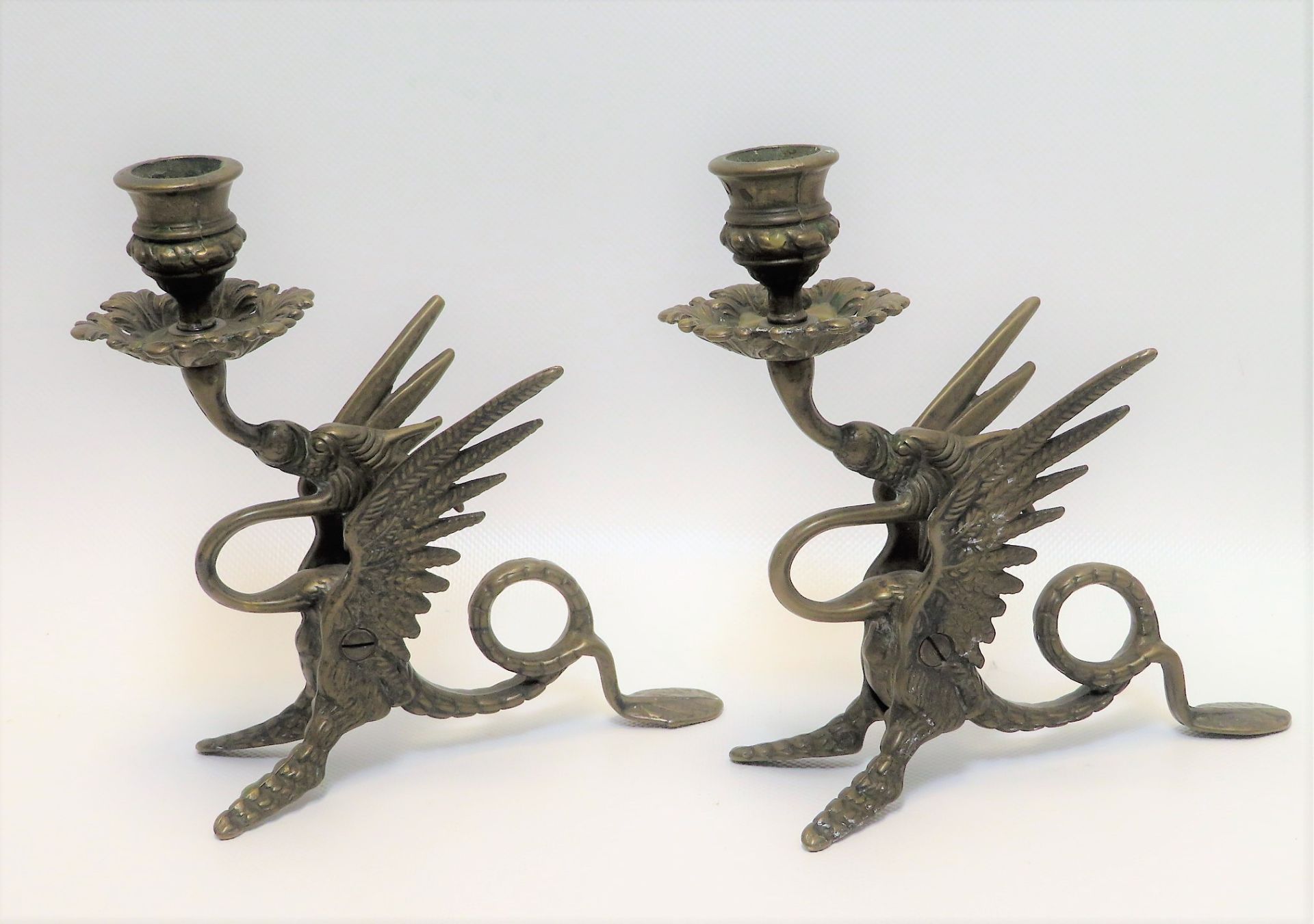 2 Kerzenleuchter in Form von Drachen, Messing, h 19 cm, d 20 cm.
