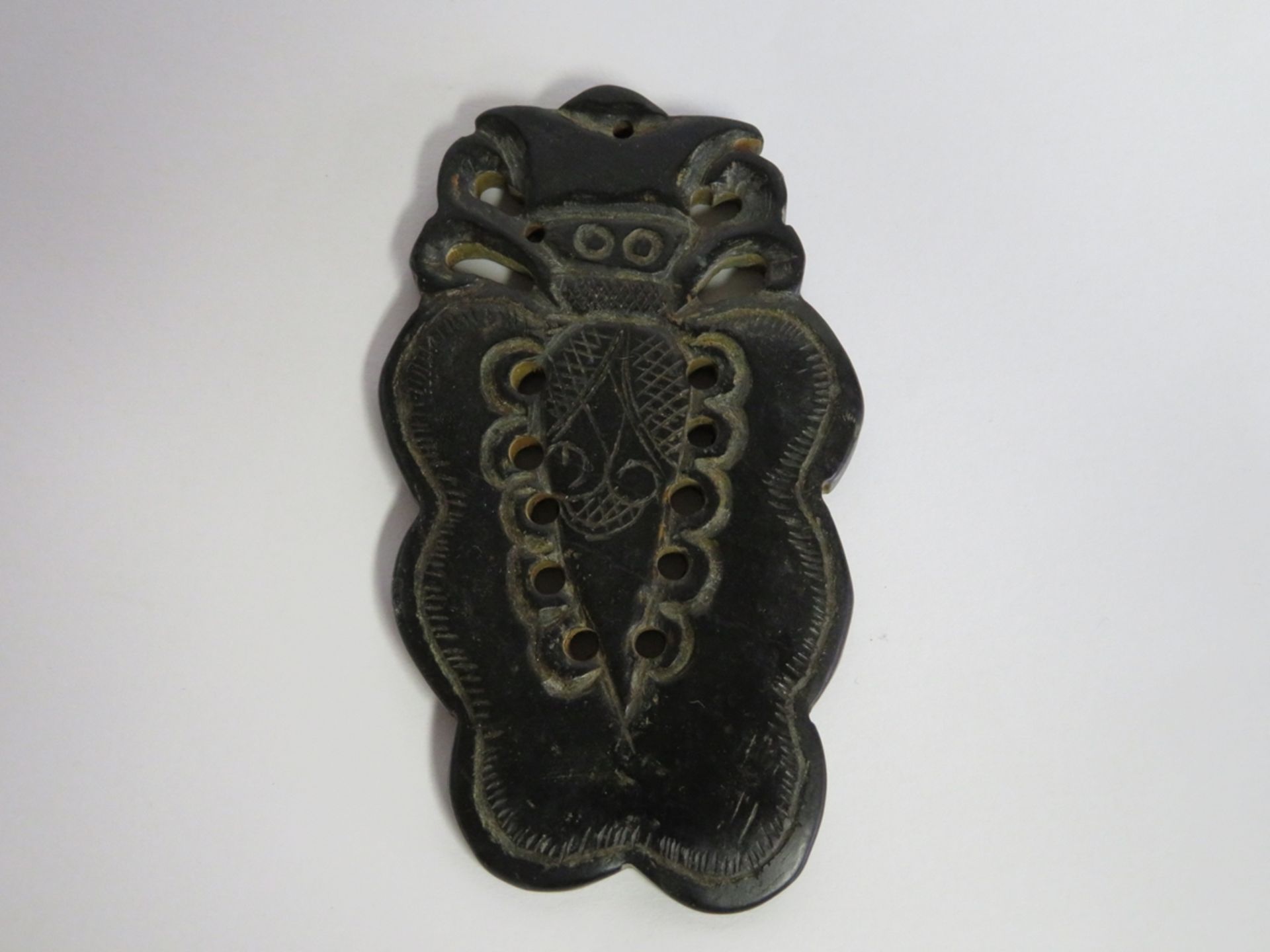 Anhänger, wohl China, grünliche Jade beschnitzt, 9,5 x 6 cm.