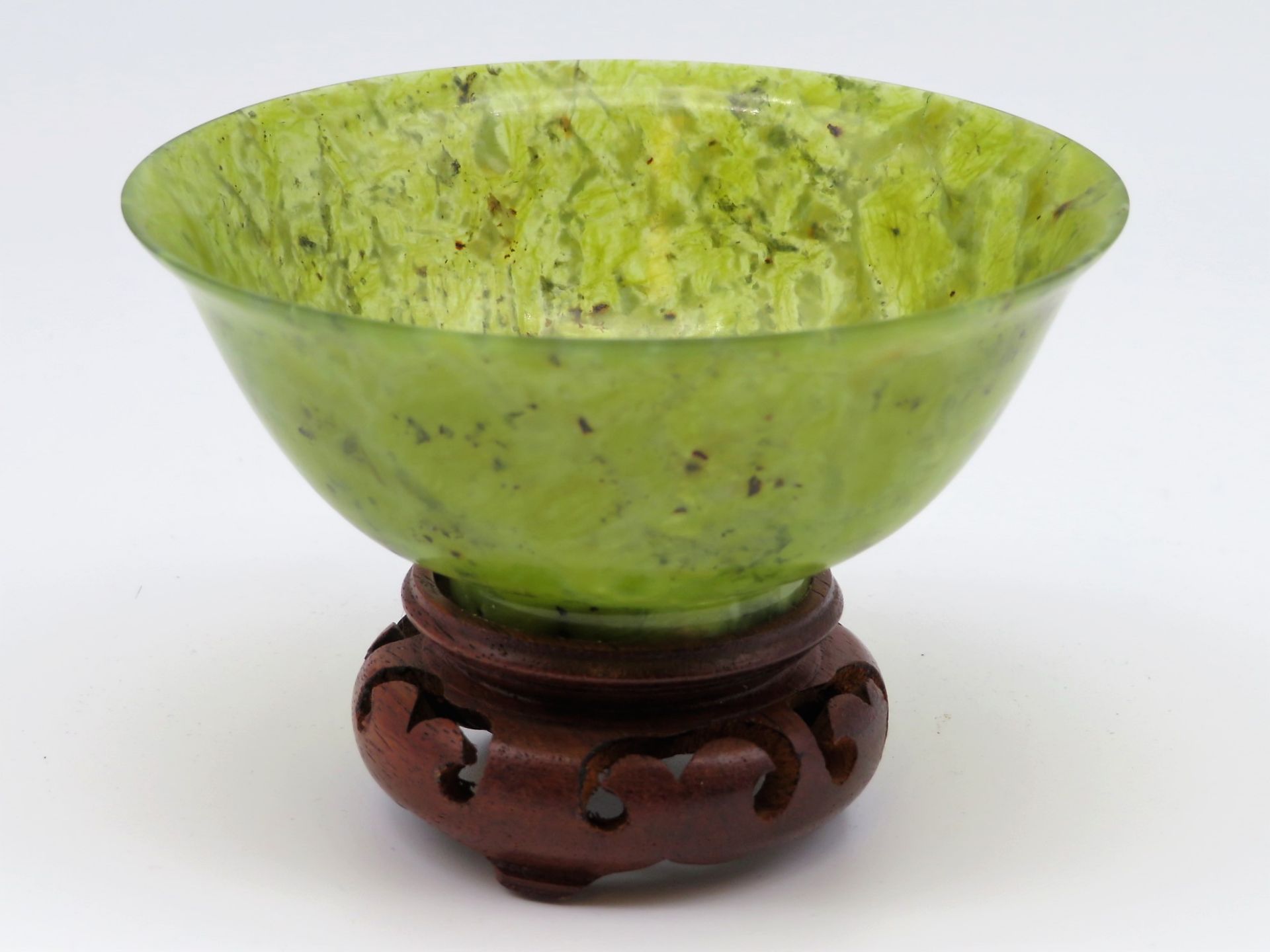 Schale, China/Japan, moosfarbener Jadeit, geschnitzter Holzsockel, Schale h 4,5 cm, d 10,5 cm.