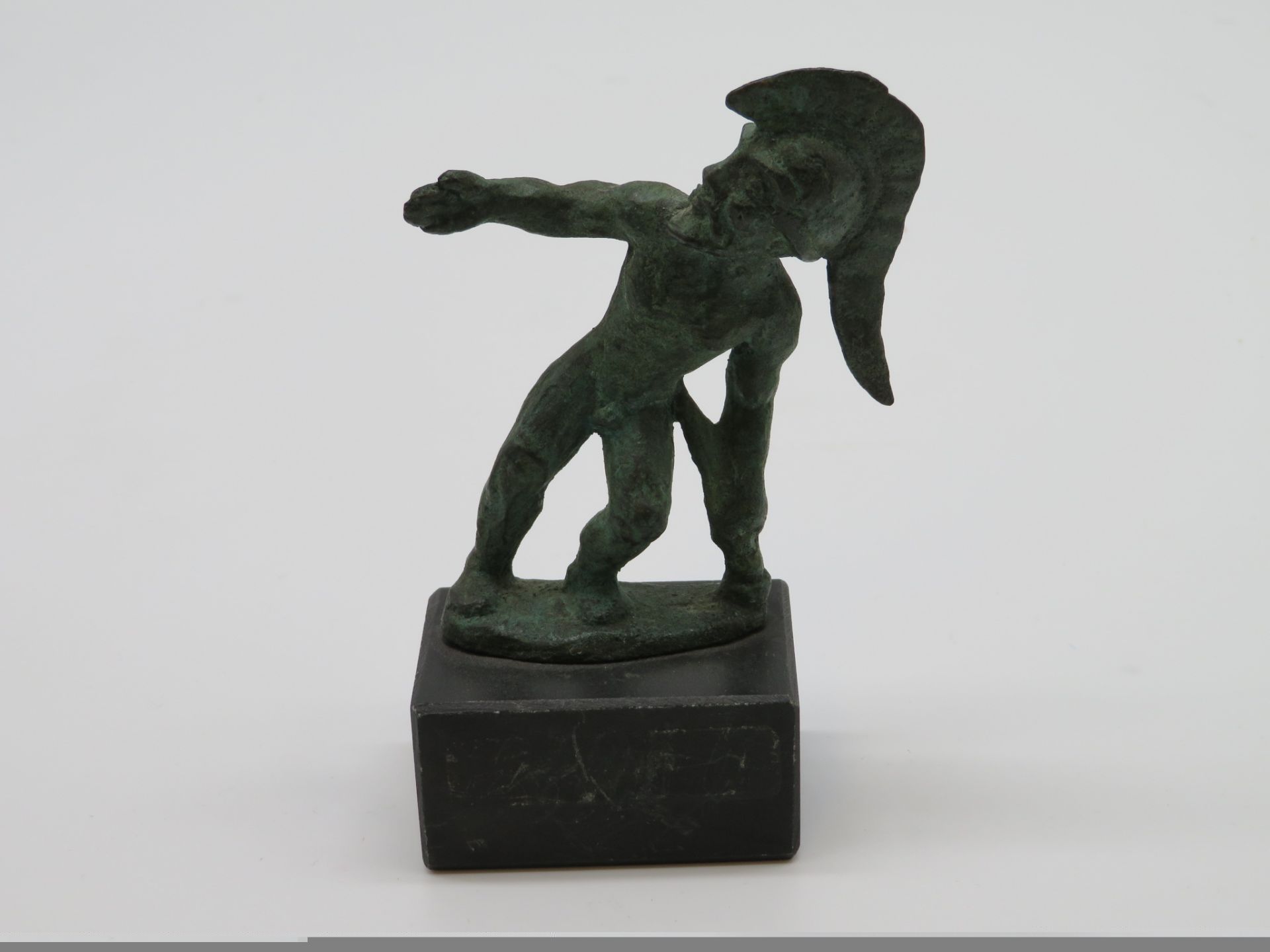 Kleinbronze, Behelmter Krieger, Bronze patiniert, h 9,5 cm, d 8 cm.