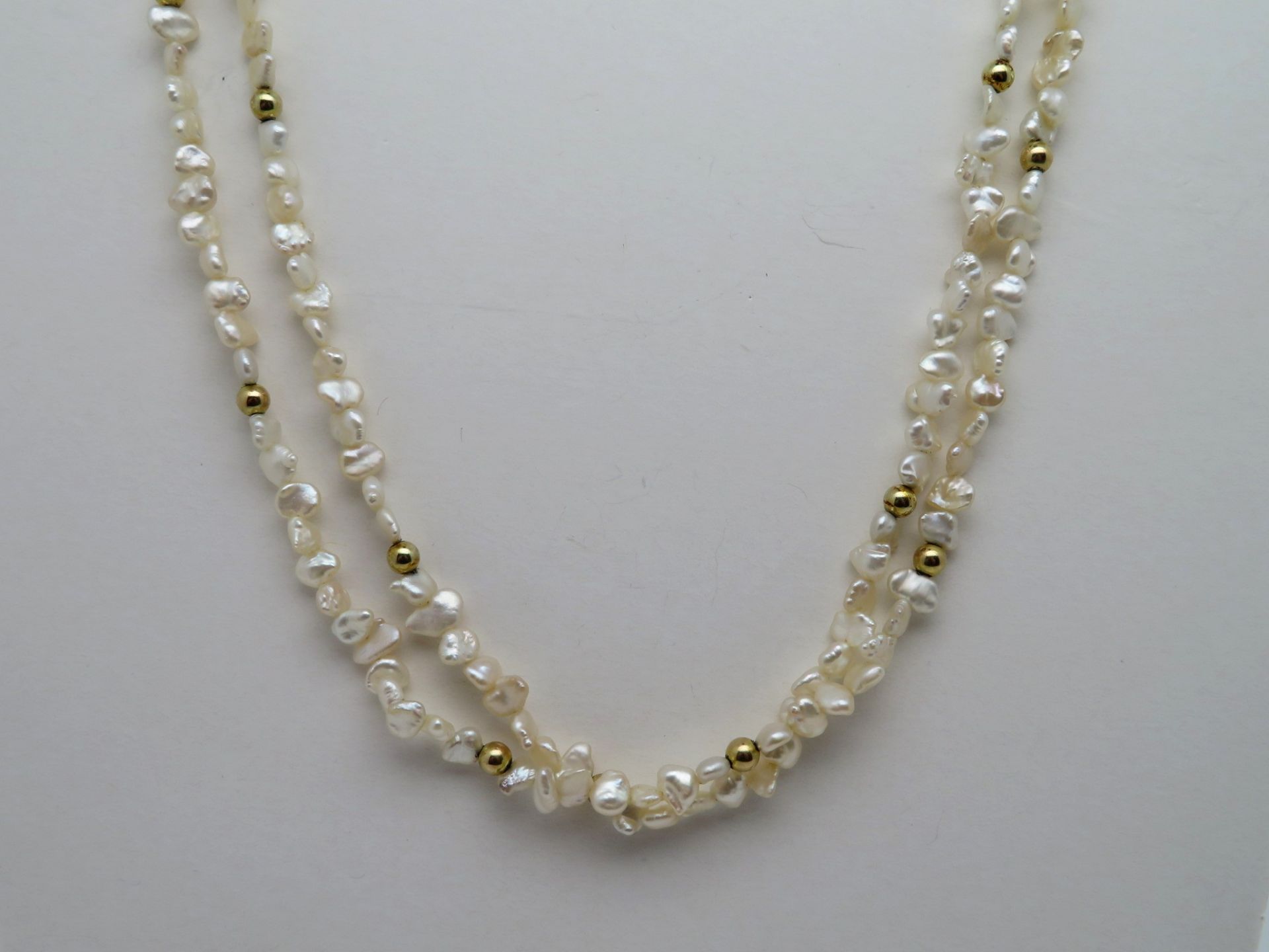 Lange Biwa-Perlenkette, Schließe und Zwischenstücke 18 kt Gelbgold, l 122 cm, ca. d 0,6 cm.