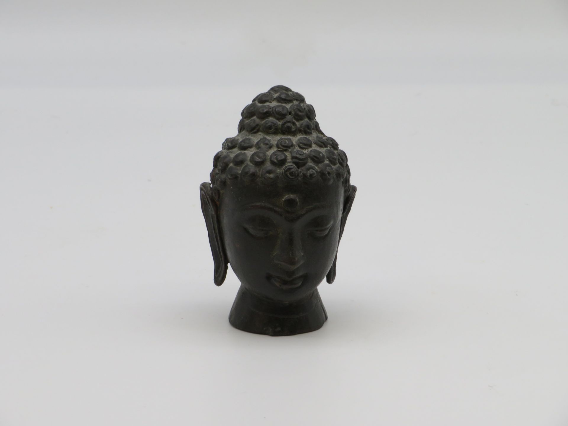 Buddhakopf, wohl Kambodscha, Bronze, h 10 cm, d 6,5 cm.