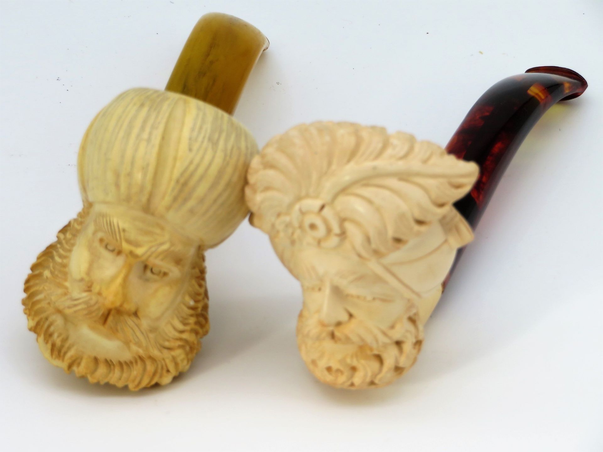 2 Meerschaumpfeifen, um 1900, mit Orientalen-Köpfen beschnitzt, l 12,5 cm, d 4,5/3,5 cm.