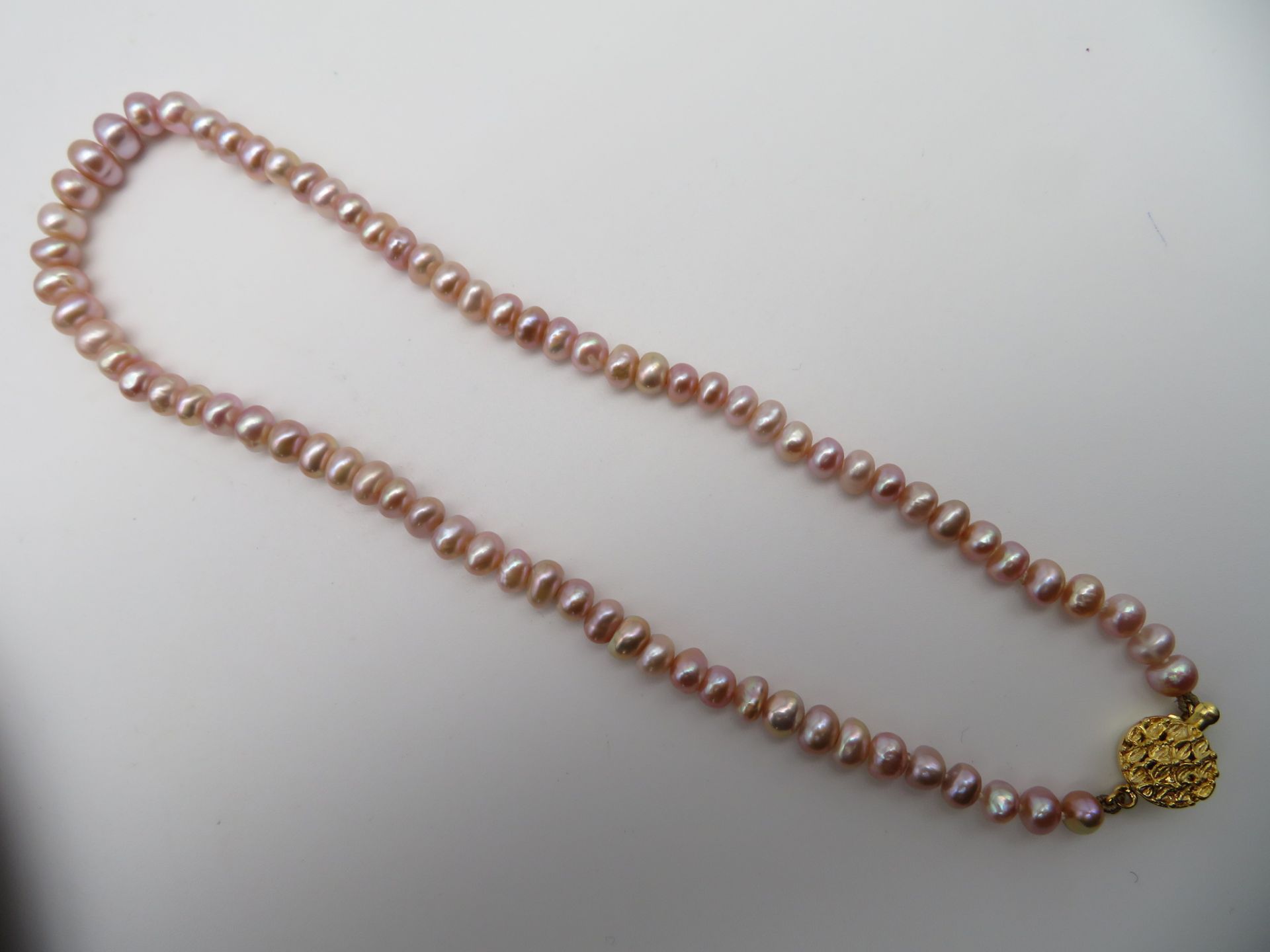 Perlenkette mit 14-Karat vergoldeter Schließe, einreihig, roséfarbene Perlen, l 40 cm, d 0,6 cm.