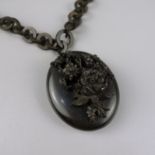 Medaillon an Ringkette, Trauerschmuck, um 1890ovales Medaillon mit plastischem Blumenbukett