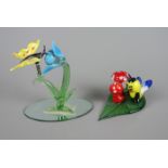 2 Glasfiguren mit InsektenSchmetterling an Feder auf großer Blume, auf ovaler Spiegelplatte,