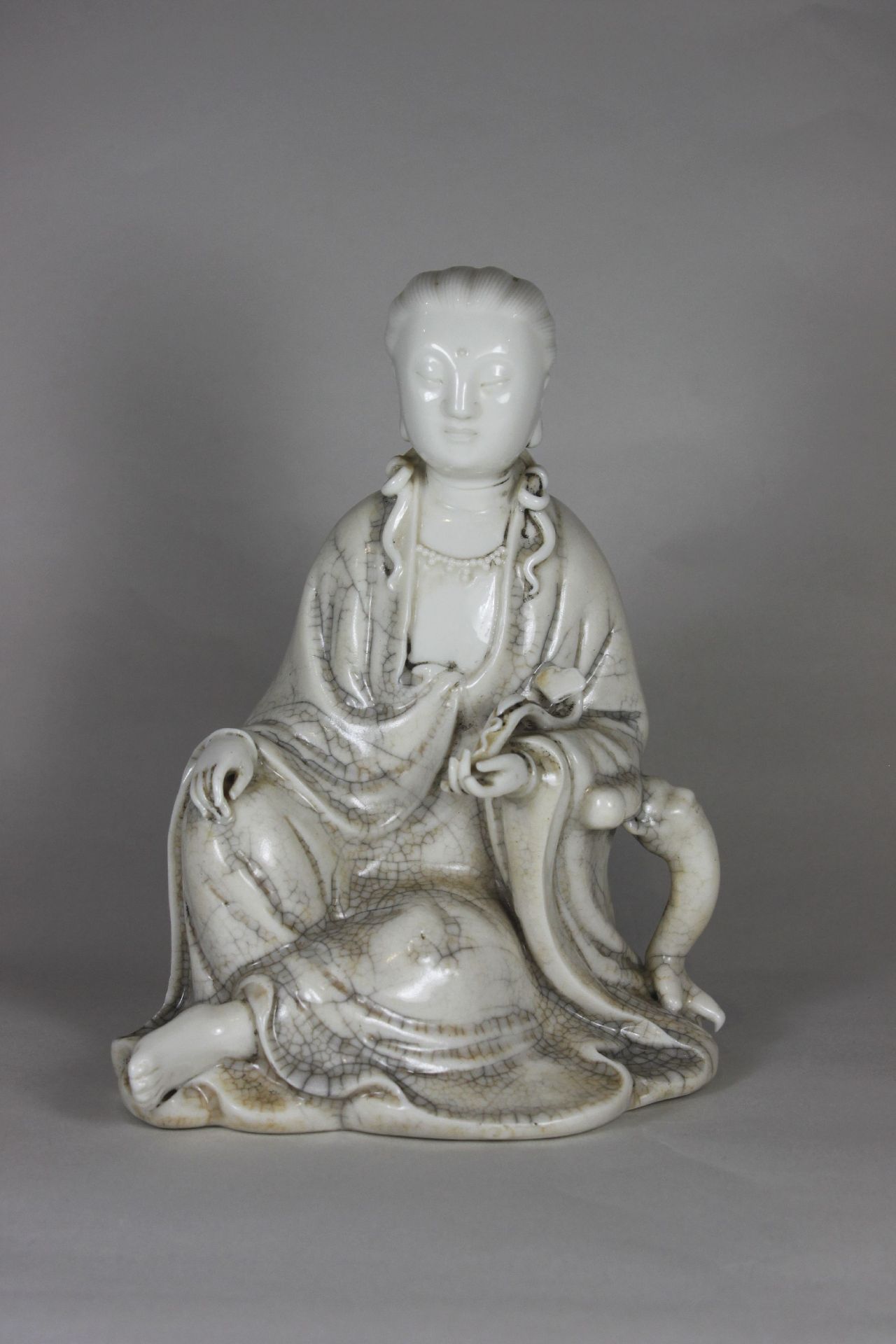 Blanc de Chine Figur, Guanyin, China, Porzellan, sitzend, innen Hohl. H.: 18,5 cm. Altersbedingter<