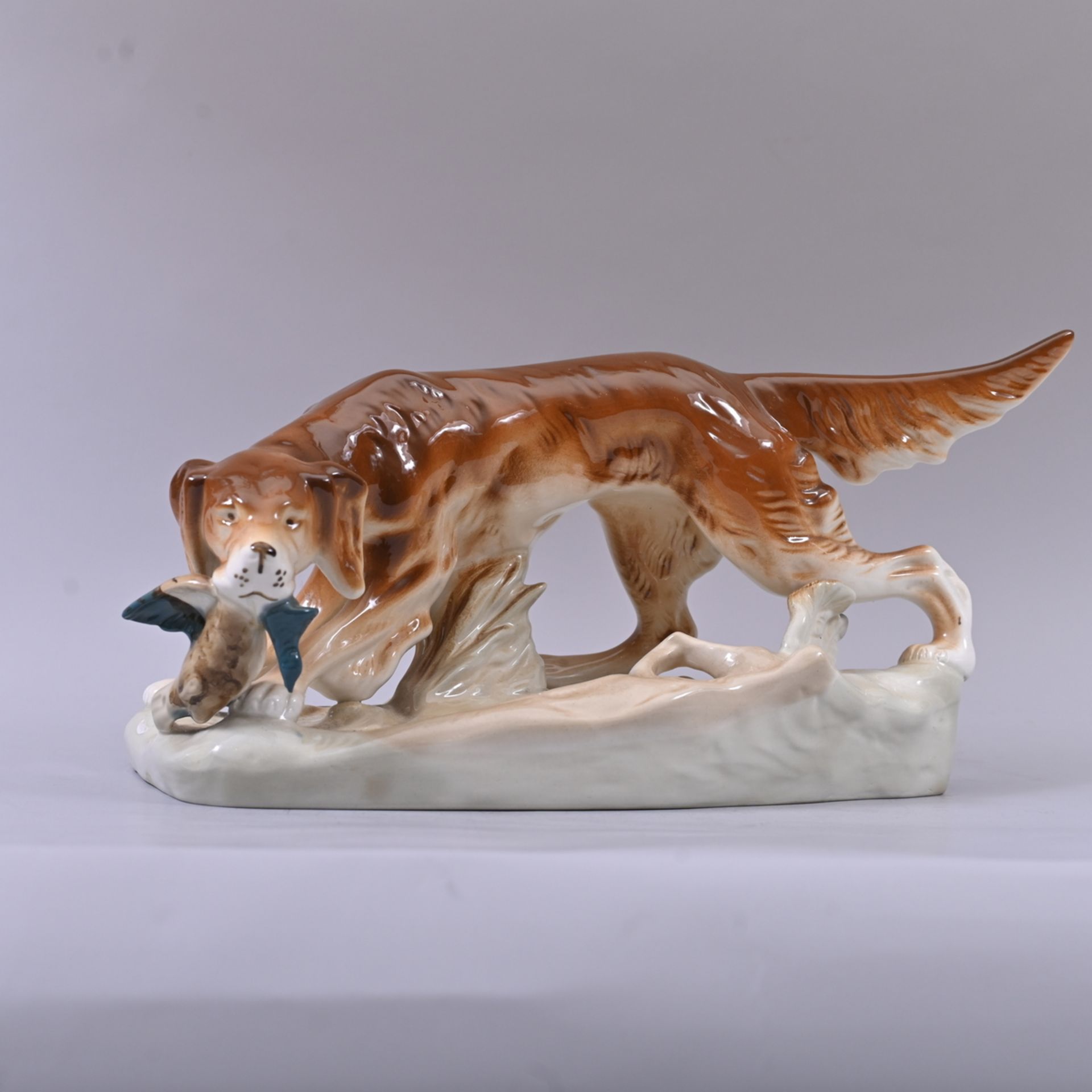 Royal-Dux, Jagdhund Irish Setter mit Beute, um 1950, heller Scherben, polychrom gefaßt, guter