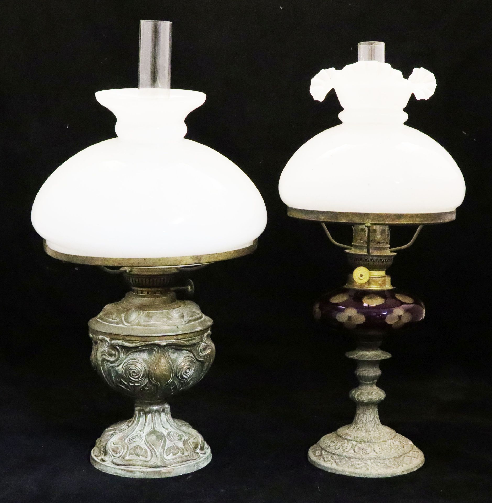 2 Öllampen, Mitte 19. Jh.: reliefiert ornamental gearbeiteter Metallfuß mit weißem Glas-