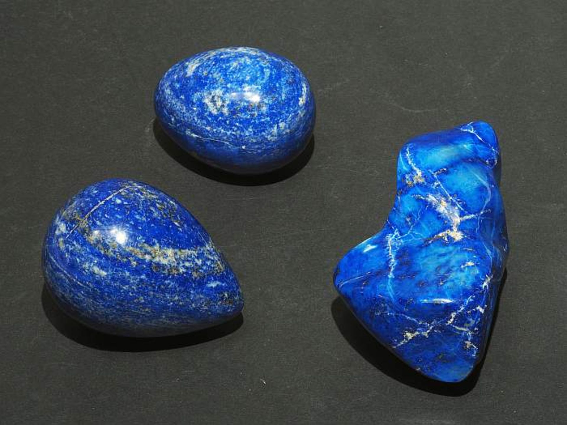 Drei Lapis-Lazuli Handschmeichler. Gemahlener Lapis-Lazuli, verschieden geformt in Ei-, Kugel. und