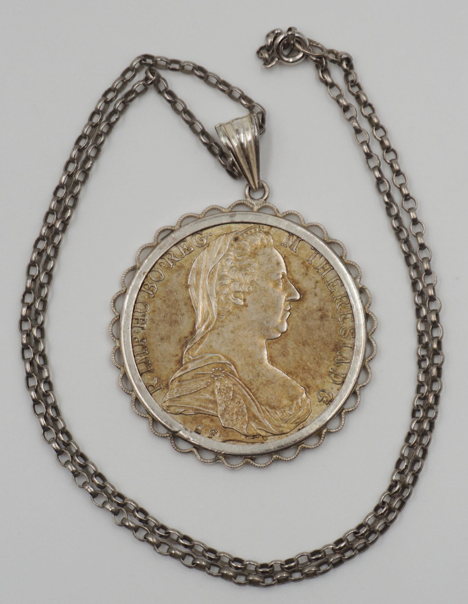 1 Kette, 1 Anhänger mit gefasster Münze, je Silber "Maria Theresia" Gsp.