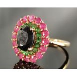 Ring, mittig großer facettierter Stein (wohl Spinell) umgeben von grünen und pinken Steinen,
