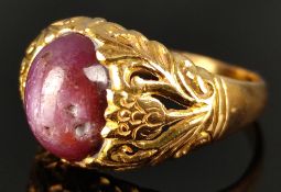 Ring mit großem dunkelrotem ungeschliffenem Cabochon, floral eingefasst in Gelbgold, gepunzt 22K (