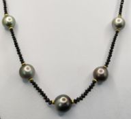 Black diamond necklace with 9 Tahiti pearls, diameter increasing towards the center, largest pearl 
