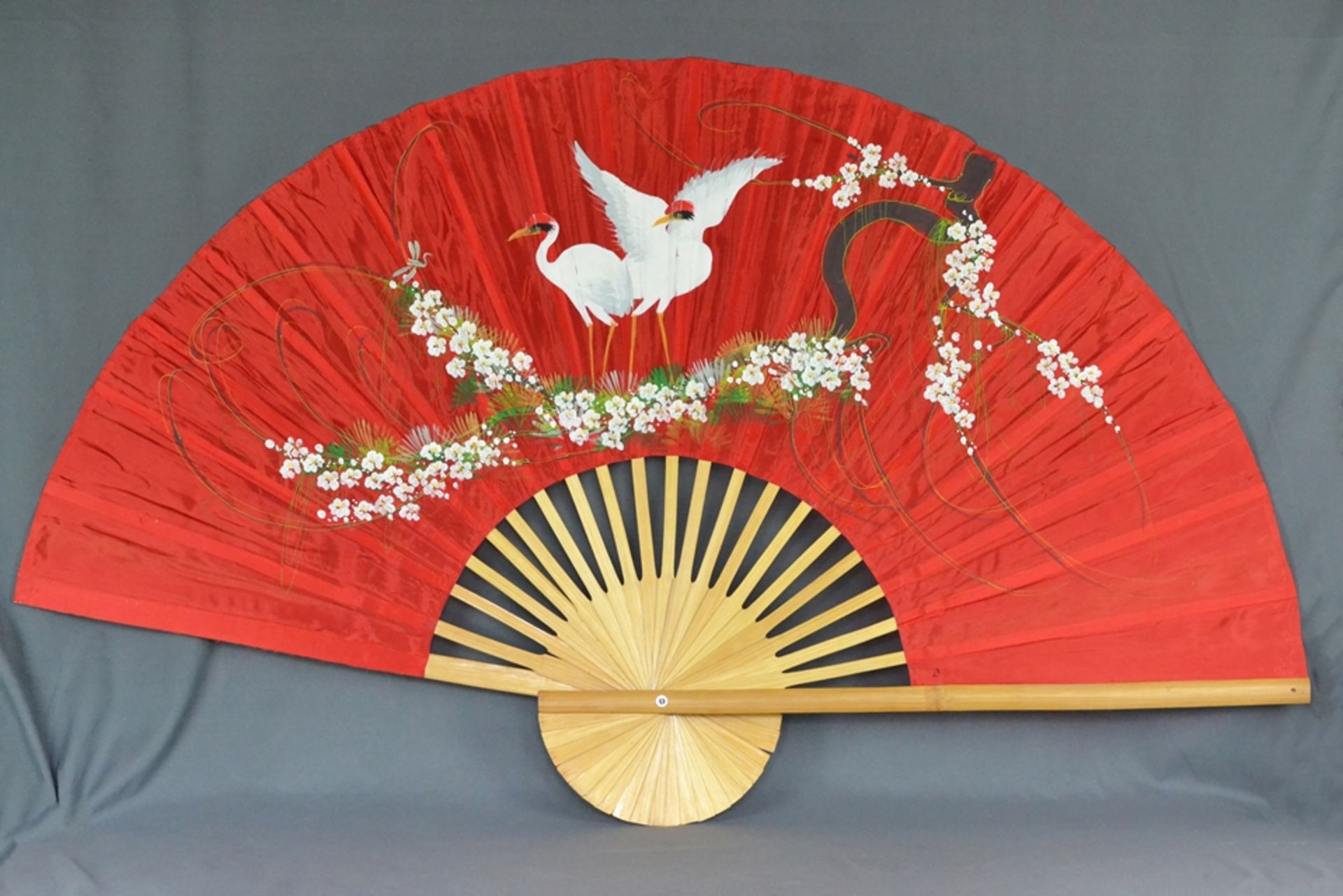 Large fan, red fabric painted with cranes and flowers, bamboo struts, 20th century, 90x148cm