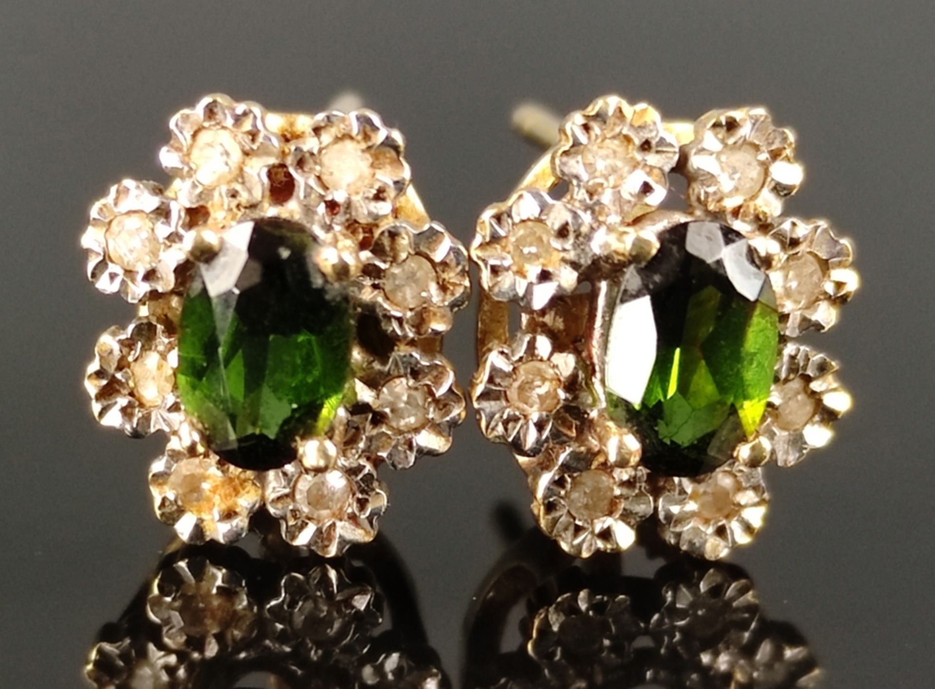 Paar Ohrringe, mittig je geschliffener grüner Schmuckstein, eingefasst von kleinen Brillanten, Fass