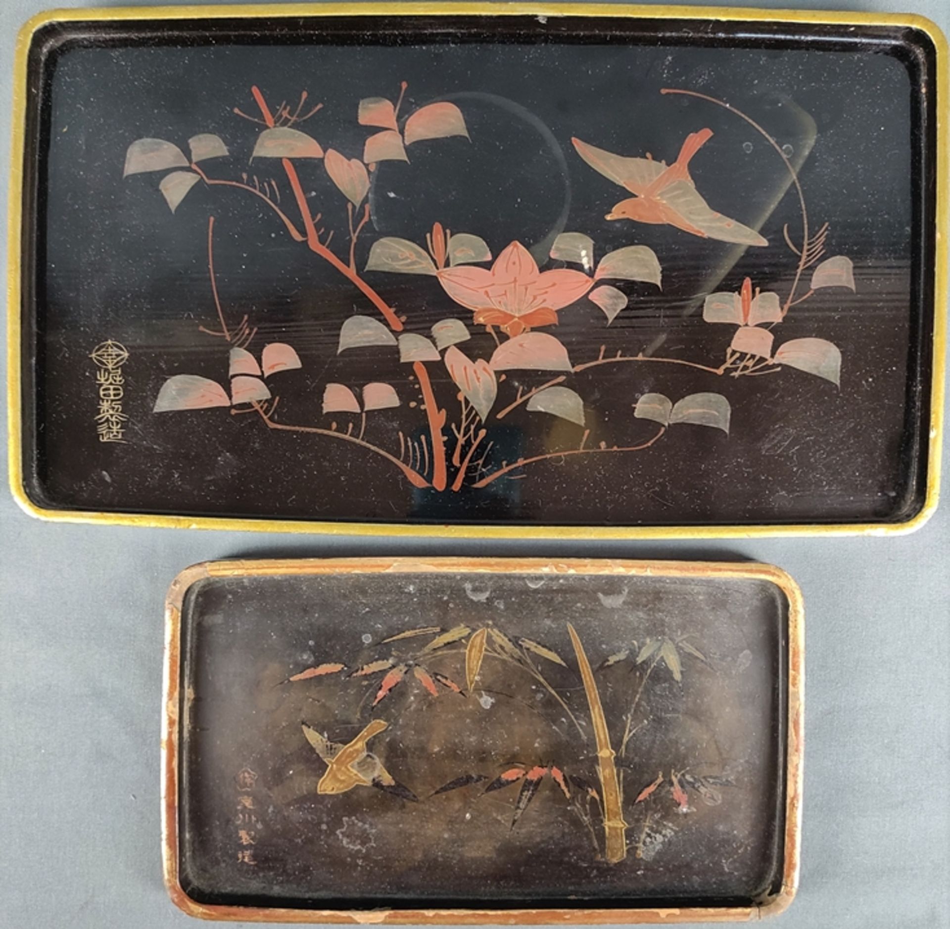 Two lacquer trays, black lacquer decorated with polychrome floral motives and bird, gold rims, each