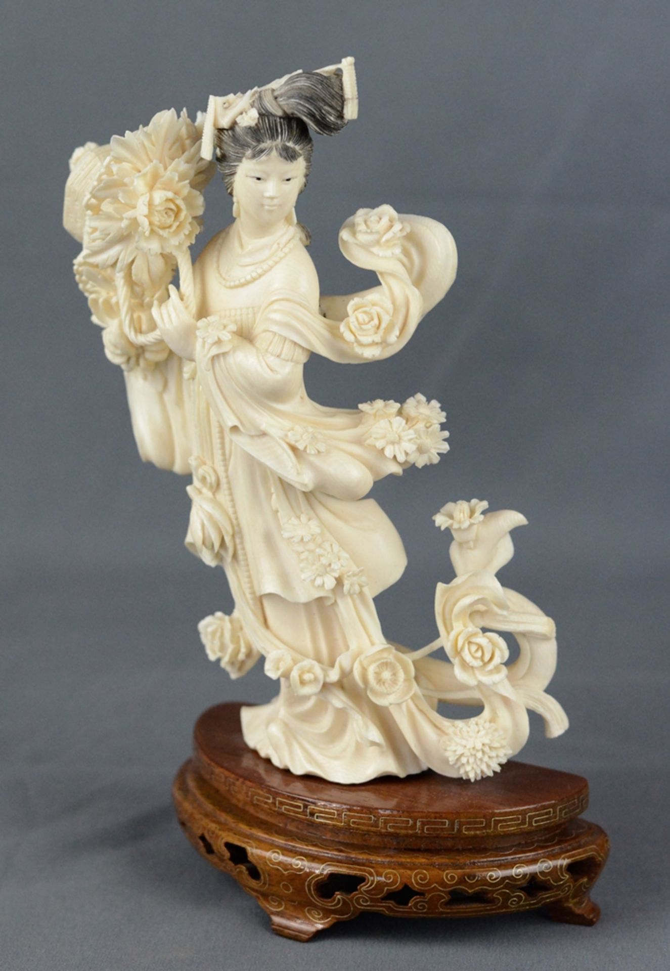 Guanyin figure, standing female figure, holding the a basket of peonies in her hands, richly decora
