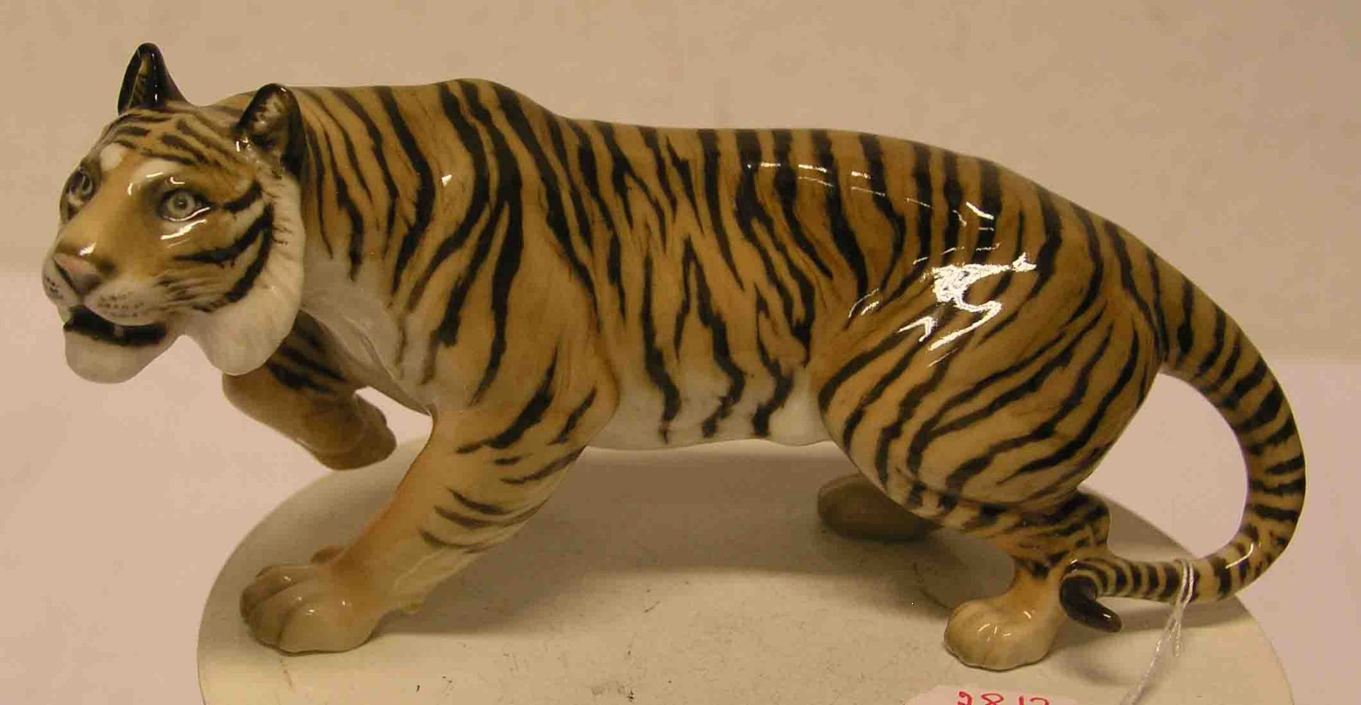 "Tiger". Porzellanfigur, farbig staffiert, Höhe: 10cm, Länge: 20cm.