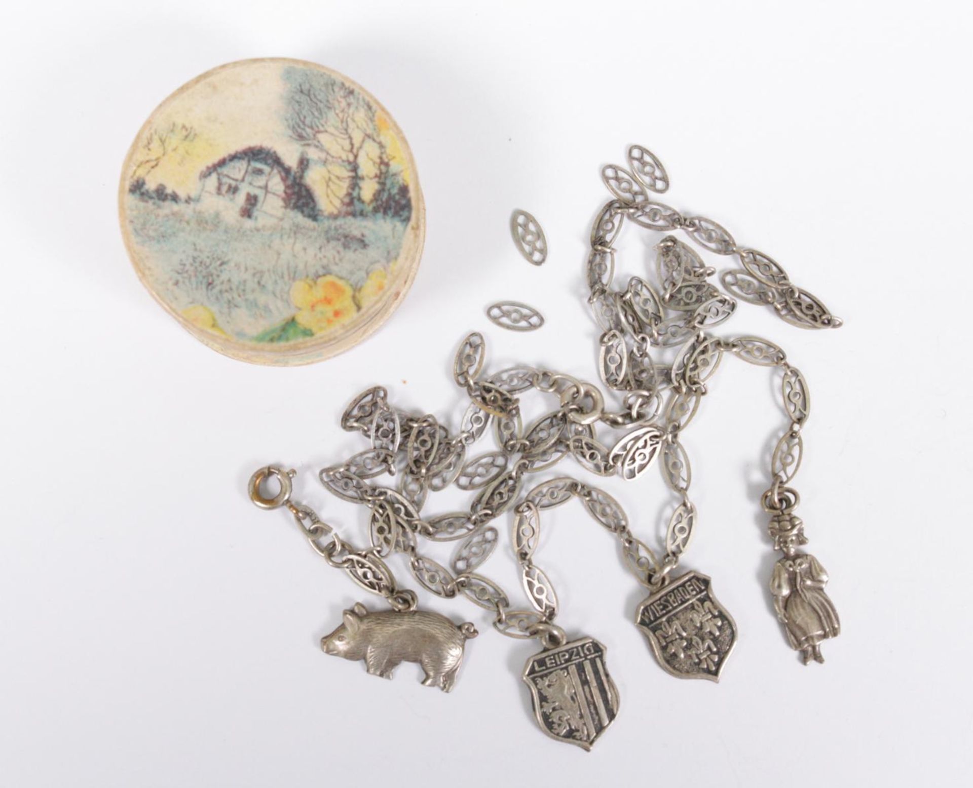 Runde Schmuckschachtel mit Bettelarmband und gerissener Halskette aus Silber